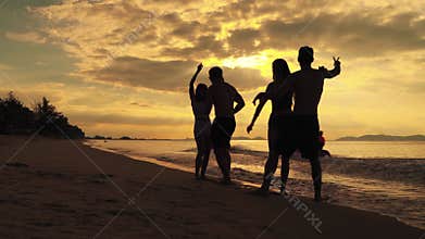 Groups of friends were dancing to celebrate a beach party in the evening when the sun was setting