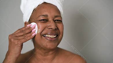 Happy African senior woman having skin care spa day