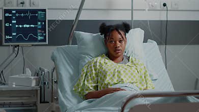 Portrait of young patient in bed with IV drip bag