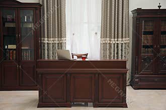 Library reading room interior with wooden bookcases and laptop on table