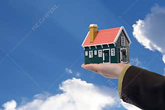 House in woman hand and sky
