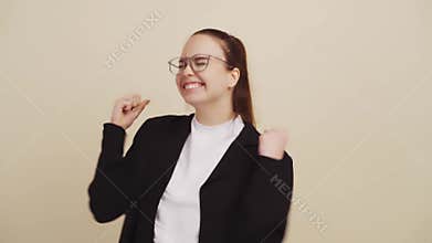 Young woman on beige background rejoices and feels happy