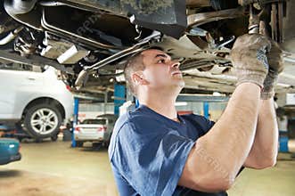 Auto mechanic at car suspension repair work