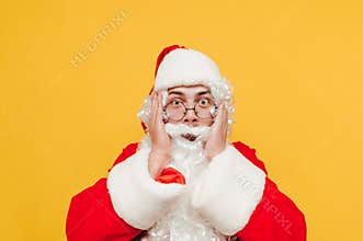Emotional Santa Claus is touching his head with his hands, looking at the camera, feeling shocked, worried and stressed before