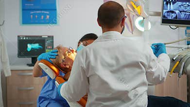 Senior woman sitting on dentist chair at dental clinic