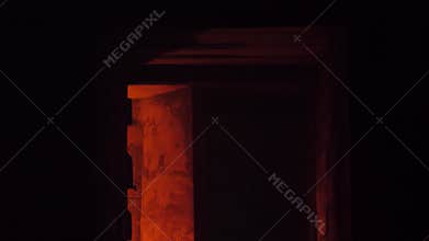 Looking on the man in hood making fire in the giant abandoned hall