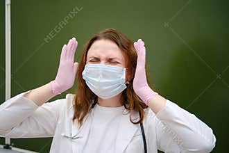 Sad school nurse in a medical mask on a blackboard