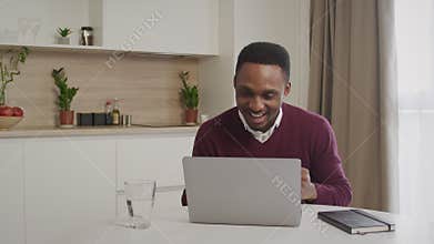 Euphoric black male student sit at desk look at laptop screen scream passing exam getting job offer. African-american