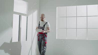 Designer examines renewable room making marks on clipboard