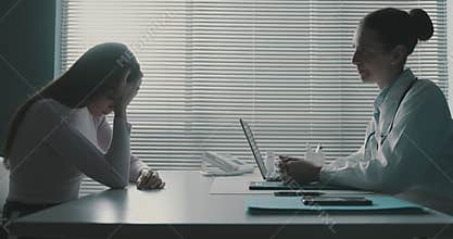 Doctor comforting a woman crying during a visit