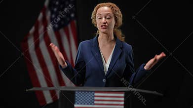 Confident positive politician woman presenting campaign from tribune talking and gesturing. Portrait of elegant female
