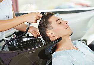 Man hair washing in hairdressing salon