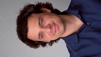 Portrait of man looking by sides with sly tricky face on gray background.