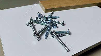 a closeup shot of a man\'s hand places different screws