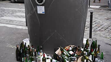 Paris, France: October 25, 2023: Bad culture of sorting garbage in Paris. A lot of empty glass bottles near recycling