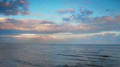 Tranquil ocean horizon at sunset, gentle waves in calm sea. Peaceful nature scene with colorful sky, reflection in water