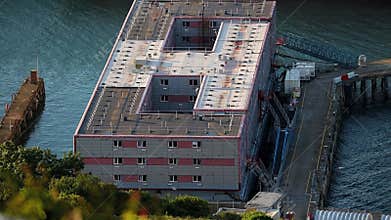 Bibby Stockholm barge from above docked on land, used house UK asylum seekers. Portland, Weymouth, Dorset, England, landscape.
