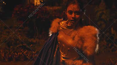 Frightened Female Warrior Stumbling in a Dark Garden with Smoke
