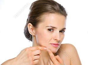 Beauty portrait of young woman squeezing acne