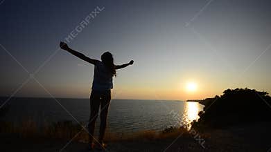 Silhouette of a woman on ocean beach enjoying her freedom