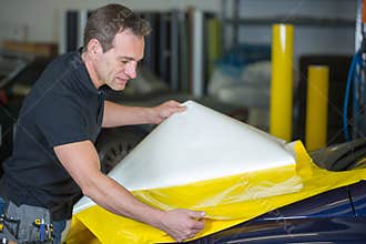 Car wrapper preparing foil to wrap a vehicle