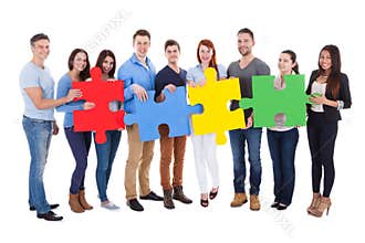 Group of people connecting puzzle pieces