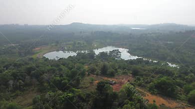 Expansive aerial journey over a verdant landscape featuring serene lakes and natural woodlands