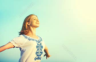 Happy young woman open her arms to the sky