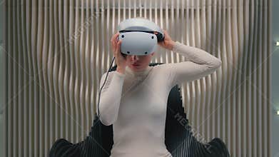Caucasian woman futuristic female girl putting on VR glasses lean back sitting in comfortable chair in futurism space