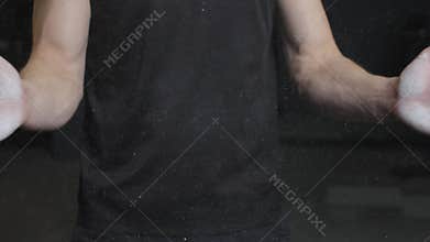 Man prepares for gym workout with chalk on hands showing strength and focus in fitness practice