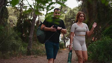 Influencer couple hiking and talking in a forest