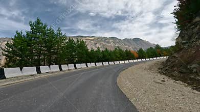 Driving along a winding asphalt mountain road. A paved road in the highlands. First-person view, filmed with an action camera