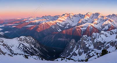 Majestic Snow Covered Mountain Range at Sunrise with Golden Light on Peaks