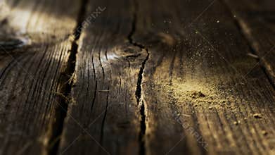 Macro Shot of Fine Wood Dust Settling on Cracked Rustic Wooden Surface with Dramatic Lighting