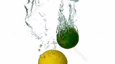 Lime and lemon plunging into water on white background