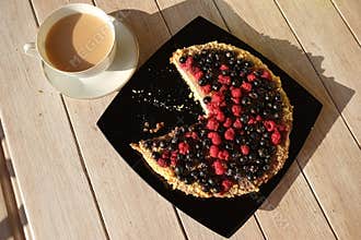 Tea with milk and a berry tart