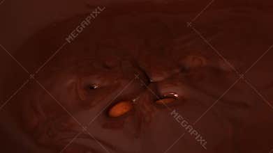 Almonds falling in melted chocolate