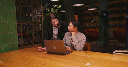 Businesswomen collaborate on modern laptop and exchange ideas