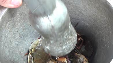 Pound crab with pestle to cook soup