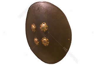 Ancient round shield with metal fittings displayed in a museum setting