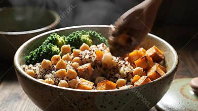Steaming Healthy Grain Bowl with Chickpeas Broccoli and Roasted Sweet Potatoes in Rustic Ceramic Bowl Close Up