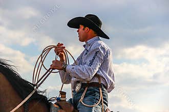 Professional Calf Roper wearing a wrangler shirt and cowboy hat