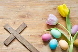 Easter eggs and cross on abstract wooden spring background