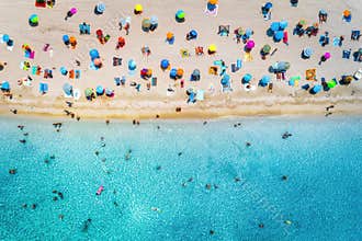 Aerial view of sandy beach with umbrellas and sea