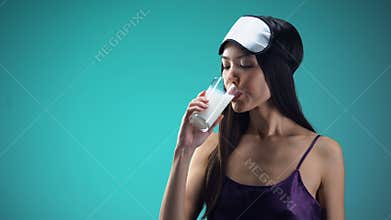 Smiling woman drinking warm milk for better sleeping, calcium and vitamin source