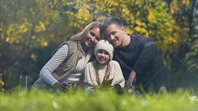 Traditional family on picnic in park smiling and looking at camera, insurance
