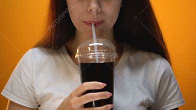 Happy girl drinking soda, enjoying sweetened drink, sugar addiction concept