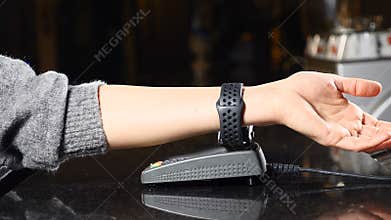 Modern payment concept. Closeup shot of Customer paying with NFC technology by smart watch on hand contactless on