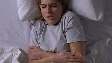 Sick woman with fever lying in bed, suffering from flu symptoms, epidemic