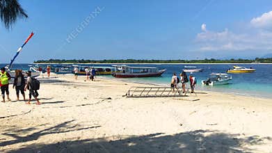 Gili Trawangan, Indonesia, 20 Mar 2019 - Tourists walking on Sandy beach with boats of Gili Trawangan, Indonesia, 4k